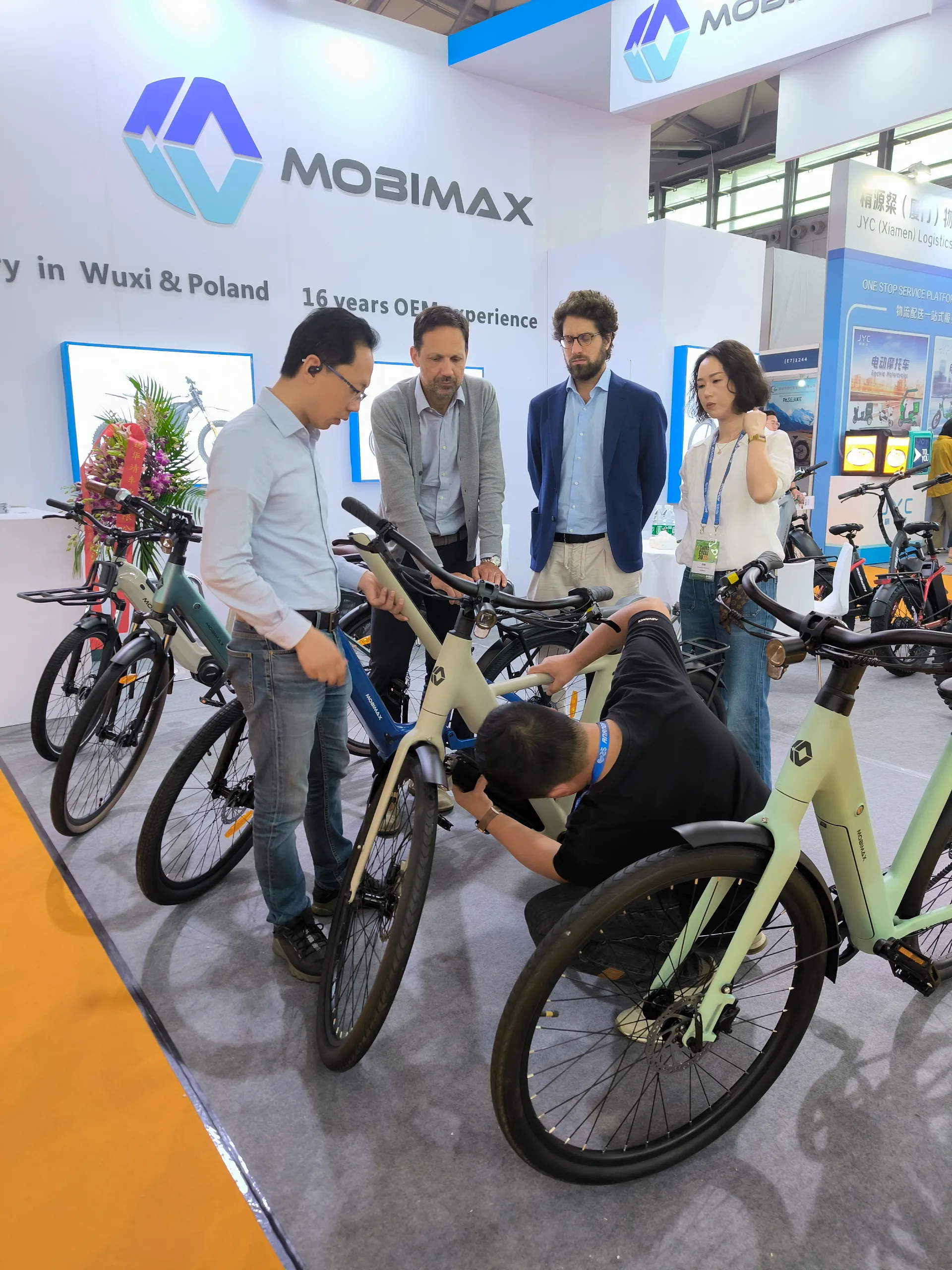 Mobimax team and visitors discussing a bicycle at an exhibition